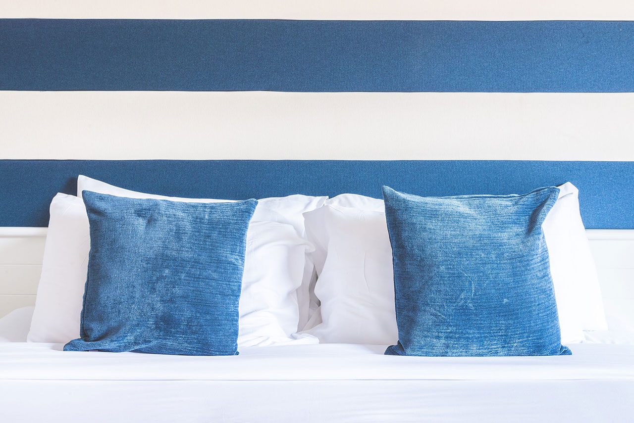 Luxury hotel-quality bed with pillows and headboard — Riviera bedroom suite